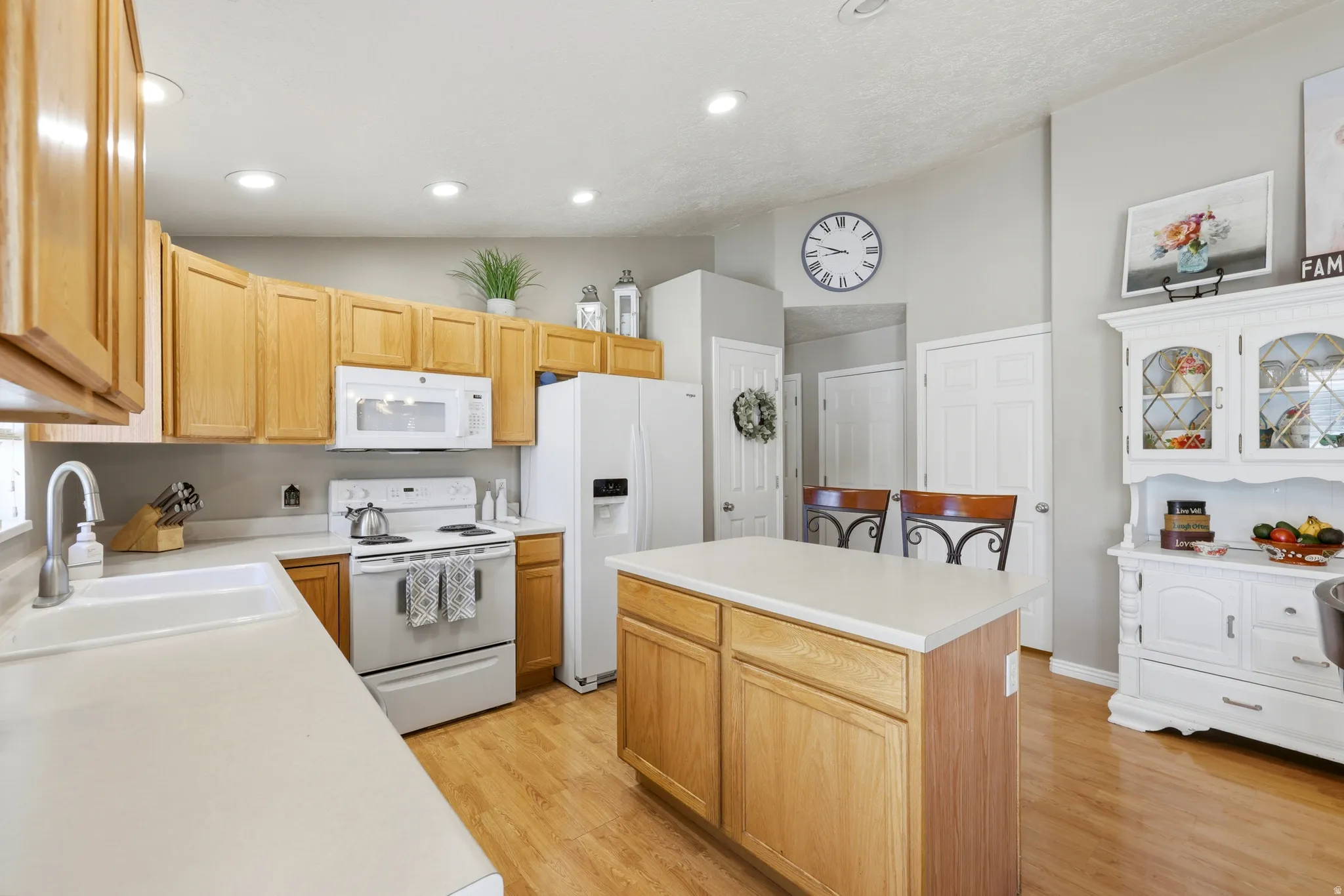 Kitchen featuring natural wood cabinetry, white countertops, a central island, recessed lighting, and wood-finish flooring