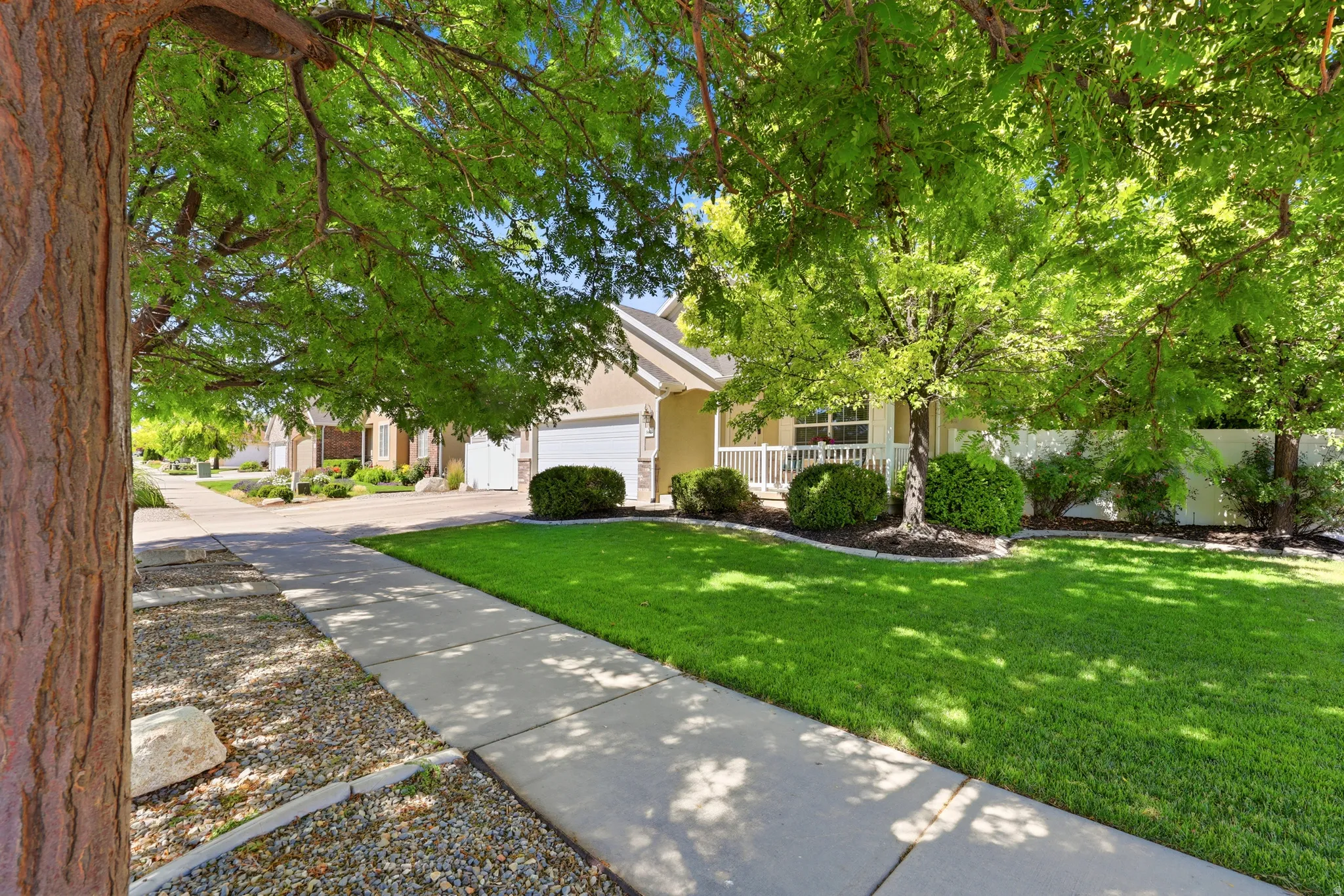 Lush green lawn and mature shade trees frame the property