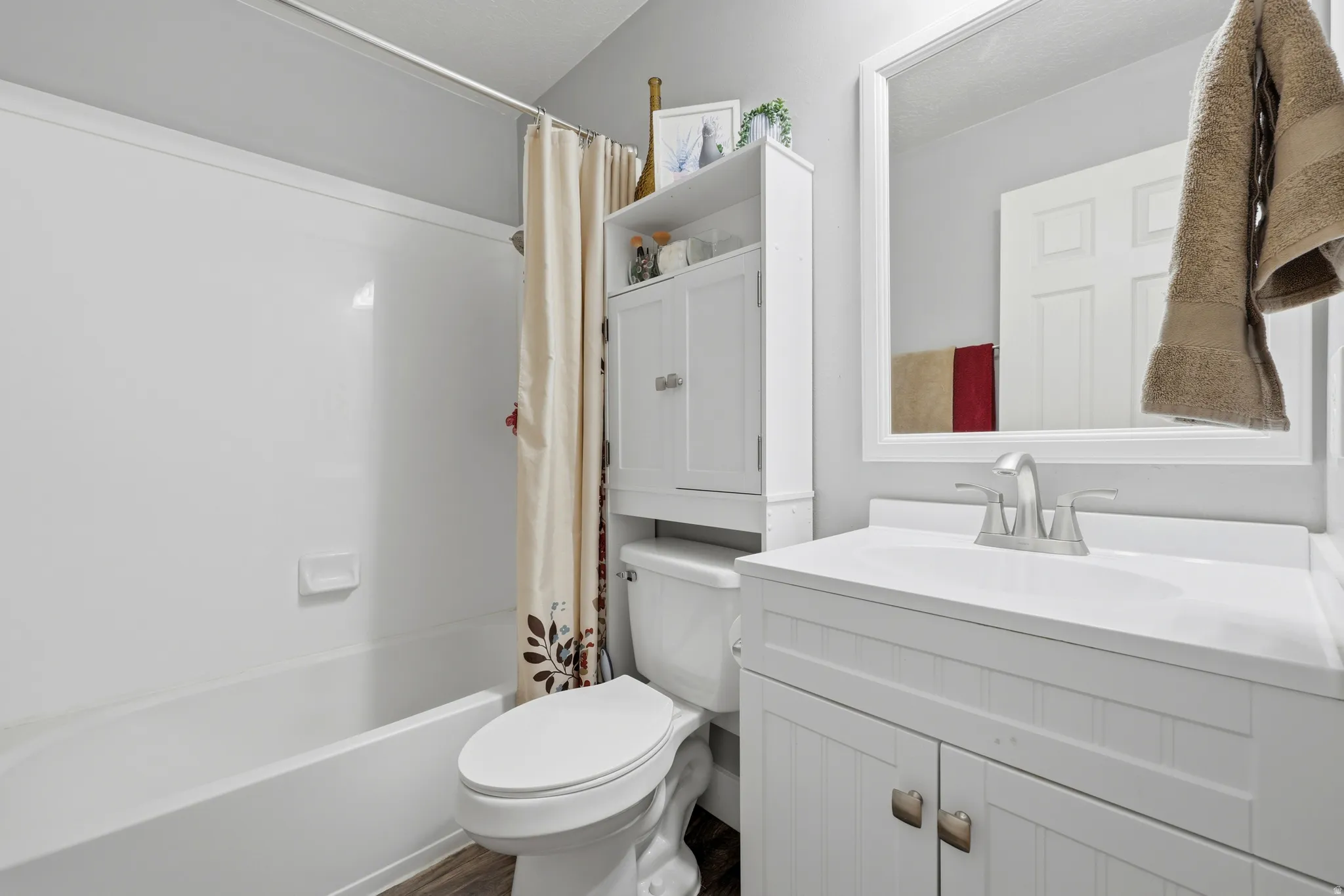 Bathroom featuring a white bathtub, toilet, and vanity with an integrated sink