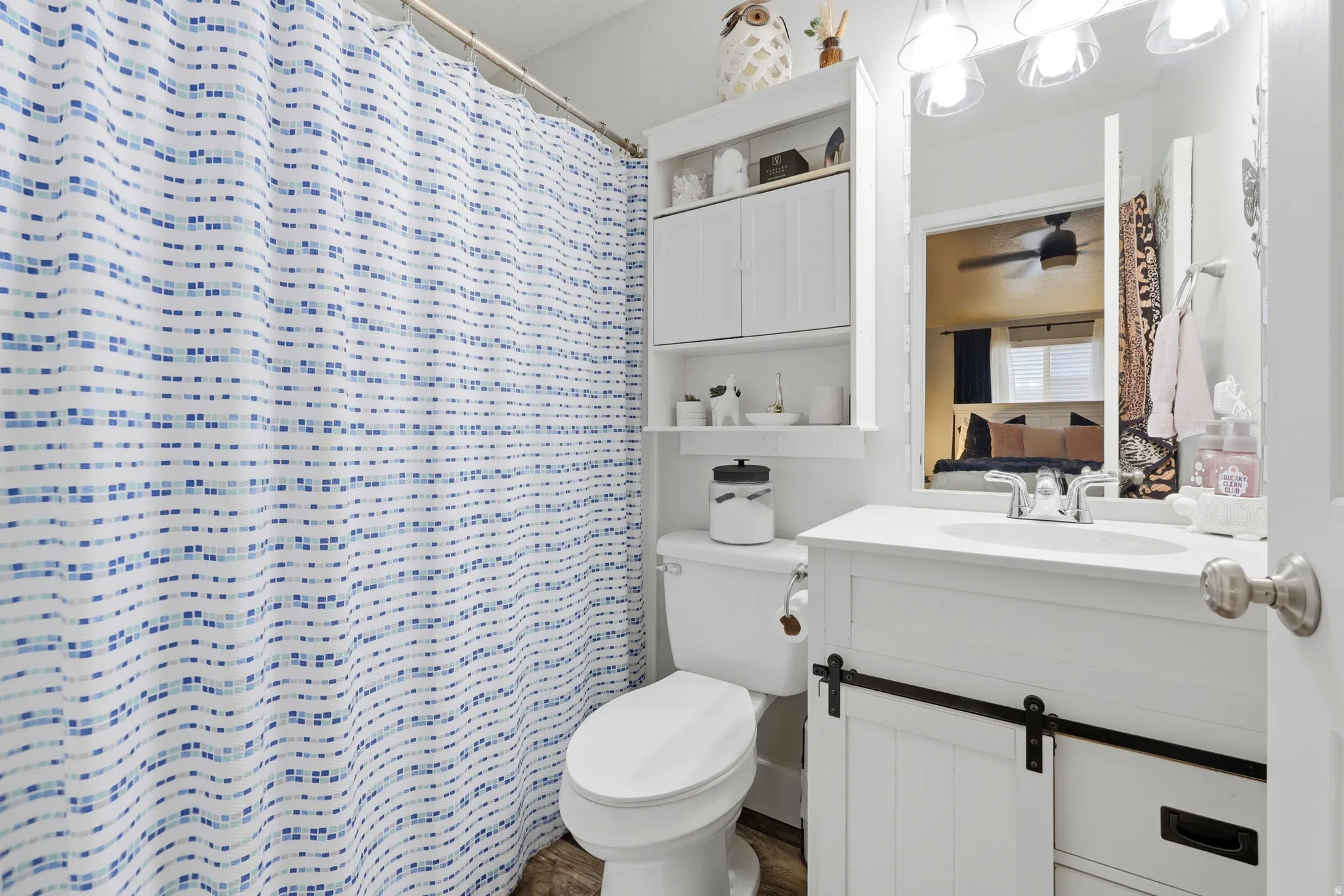 White vanity with a barn door style cabinet and an integrated sink