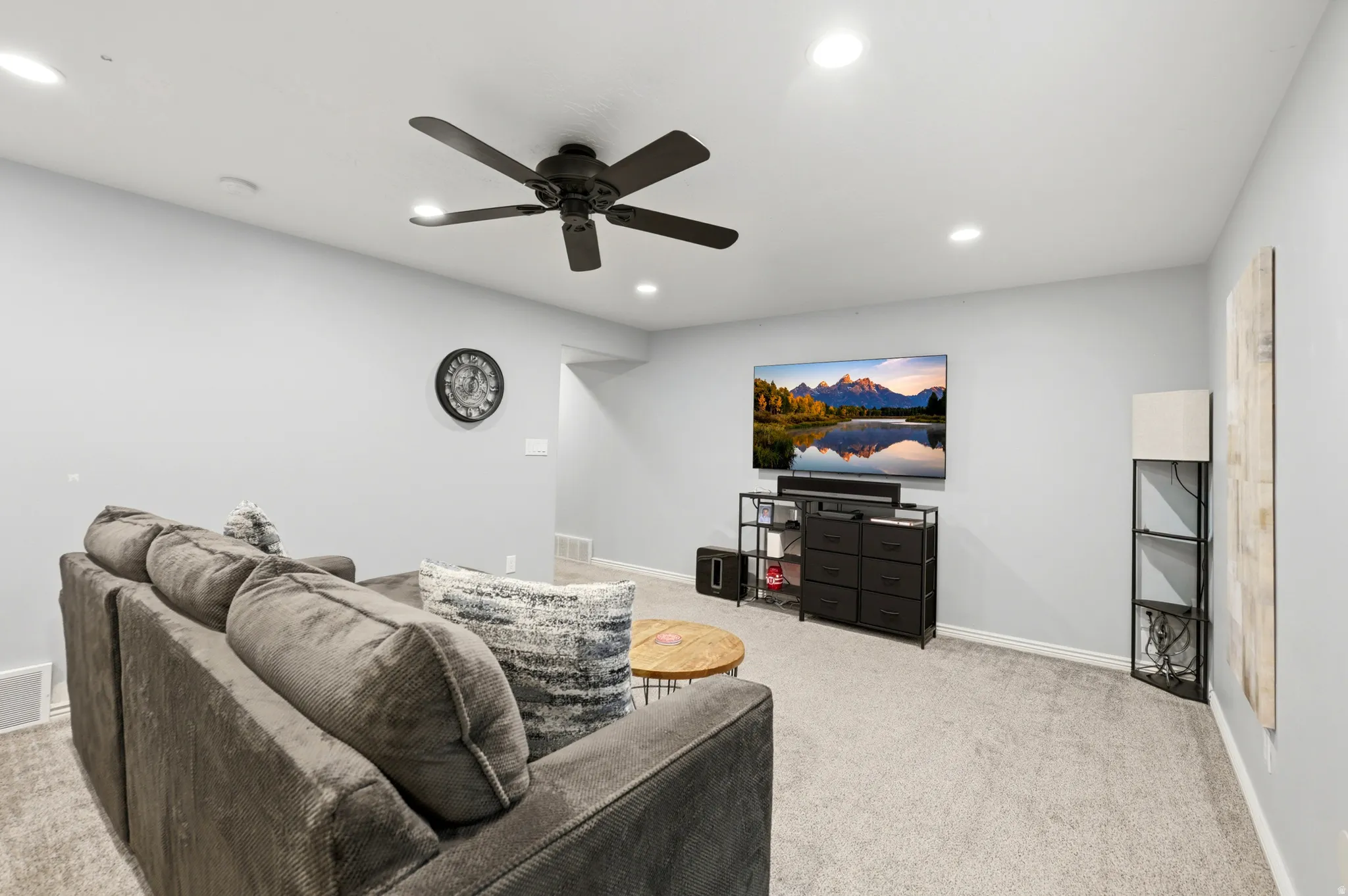 Spacious room featuring light gray walls, recessed lighting, a ceiling fan, and gray carpeting