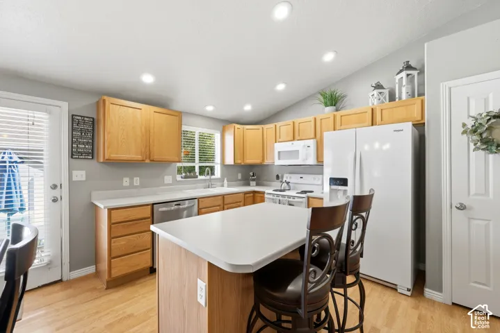 Kitchen featuring light wood cabinetry, white countertops, stainless steel dishwasher, and recessed lighting