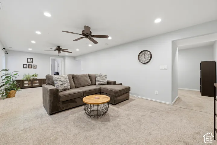 Spacious room featuring light-colored carpeting, recessed lighting, and two ceiling fans