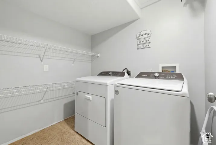 Dedicated laundry area featuring wire shelving, light grey wall paint, and beige textured flooring