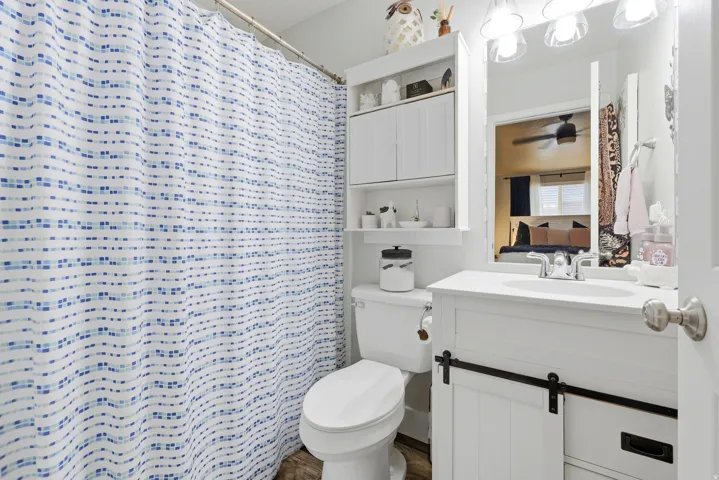 White vanity with a barn door style cabinet and an integrated sink