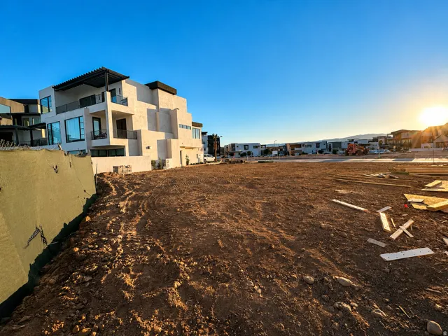 Expansive undeveloped lot with surrounding residential structures
