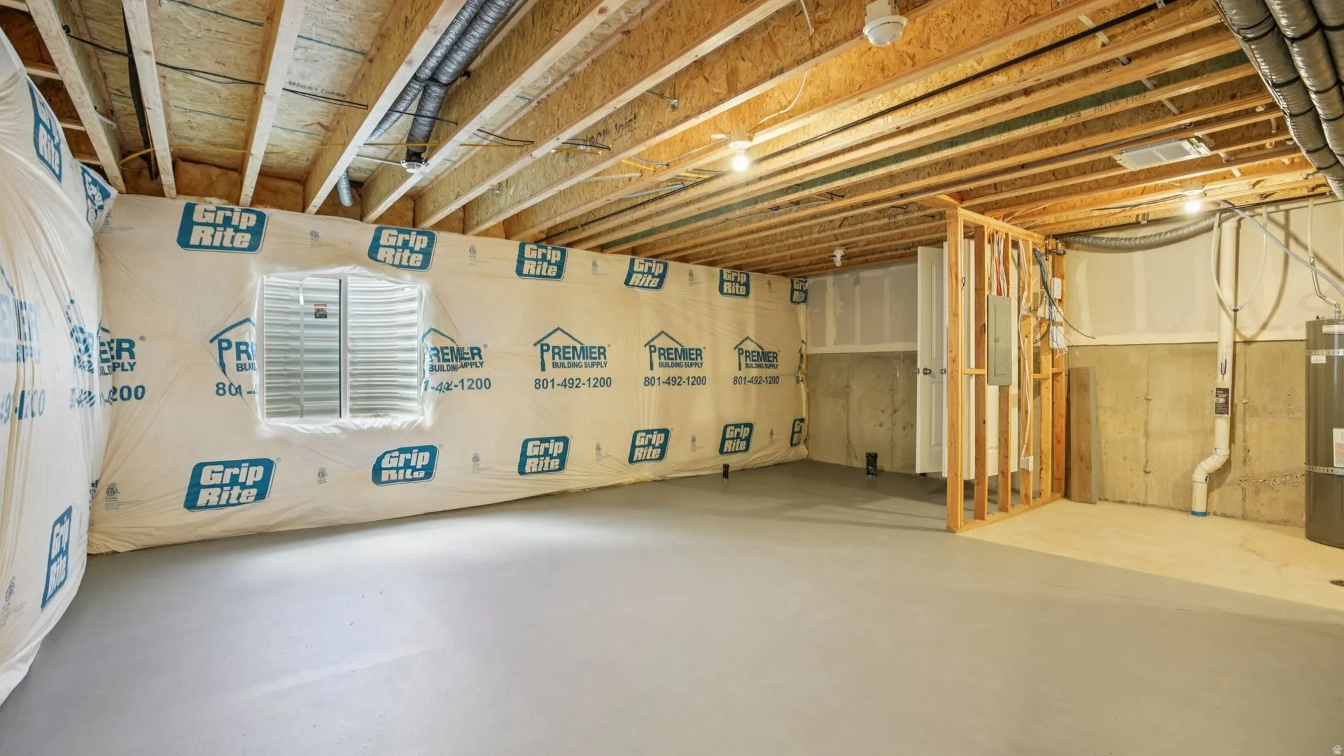 Unfinished basement space featuring exposed wood joists and concrete flooring