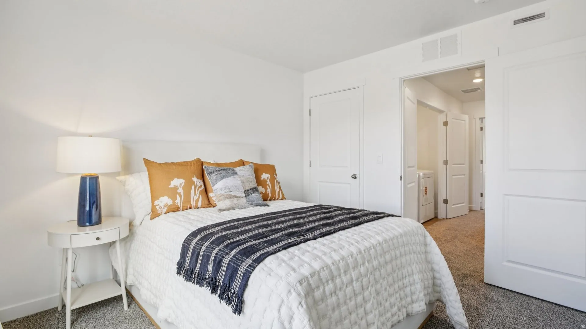 Bright bedroom featuring white walls, gray carpet, and white trim