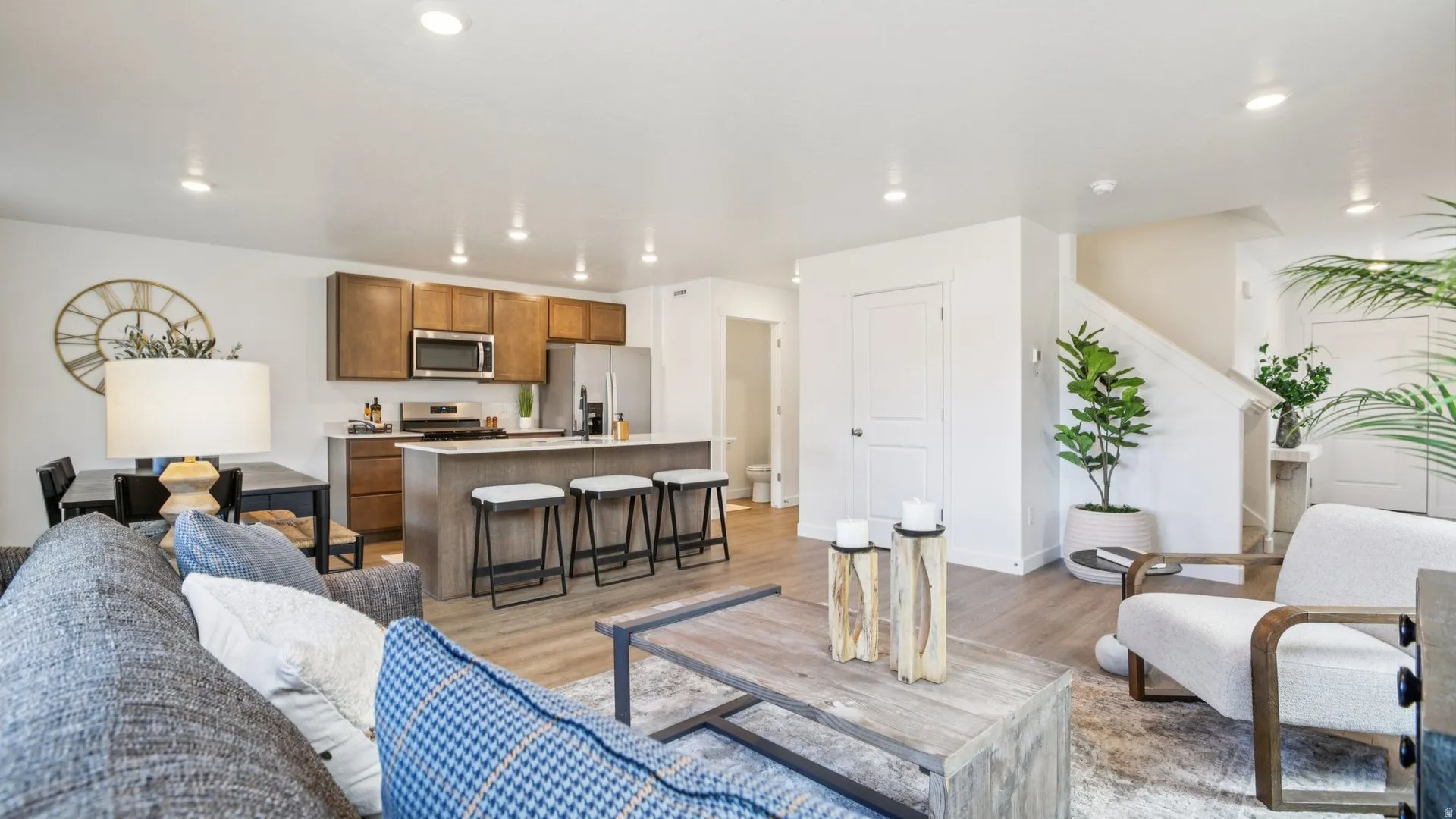 Open-concept living space featuring wood-finish flooring, recessed lighting, and a neutral color palette