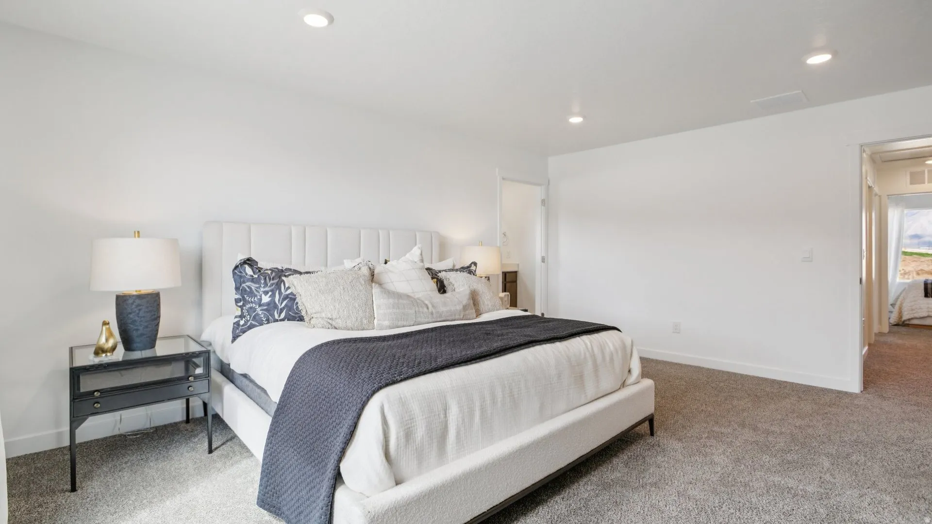 Spacious room featuring neutral carpeting, recessed ceiling lighting, and crisp white walls