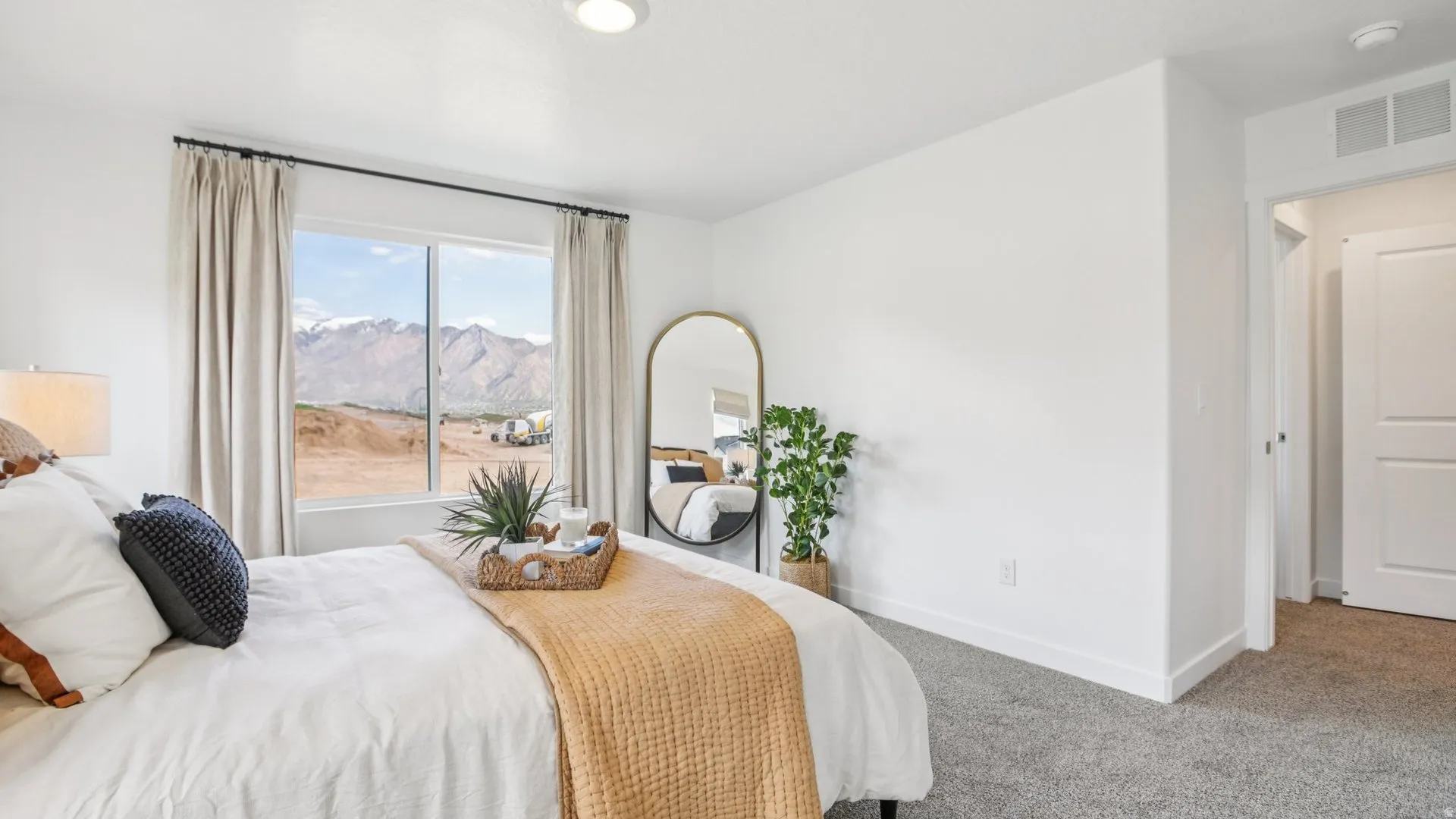 Bedroom featuring a large window with mountain scenery, gray carpet, white walls, a built-in recessed ceiling light, and a two-panel interior door
