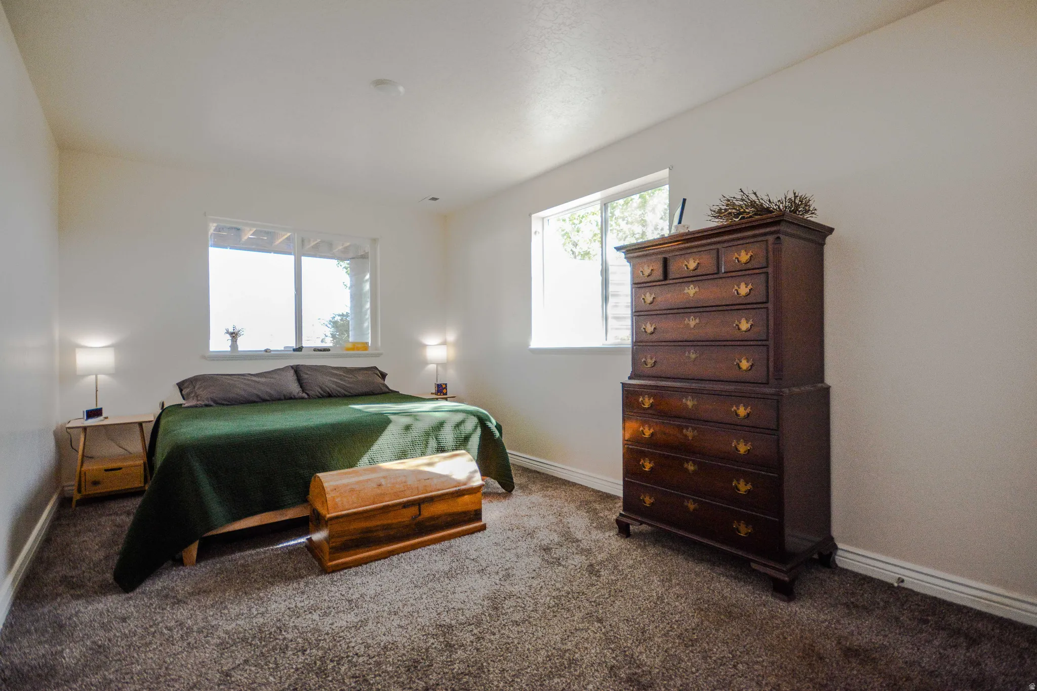 Bright room featuring a large window, neutral wall paint, and gray carpet flooring