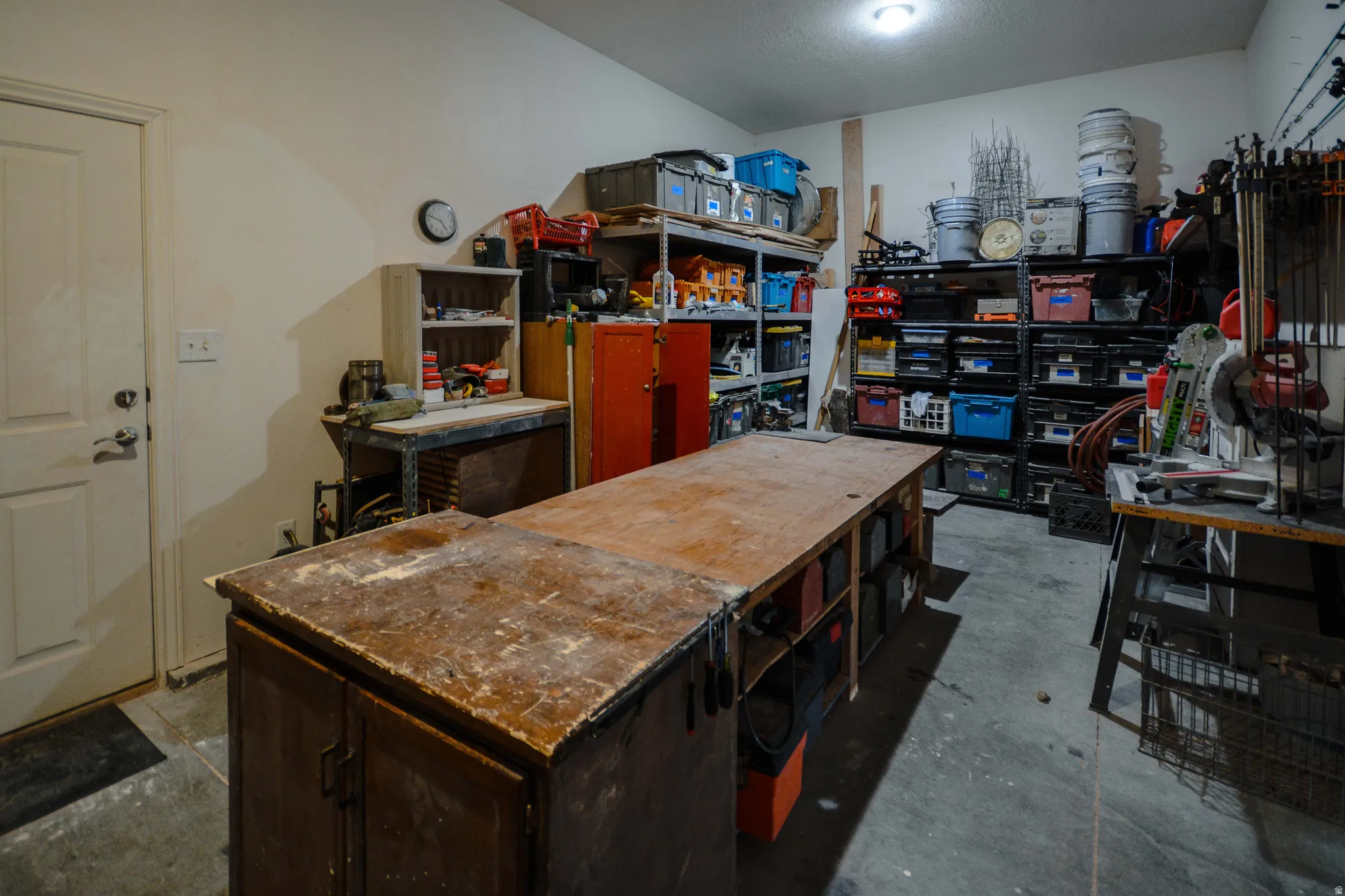 Garage featuring a concrete floor, built-in workbench, and extensive shelving for storage