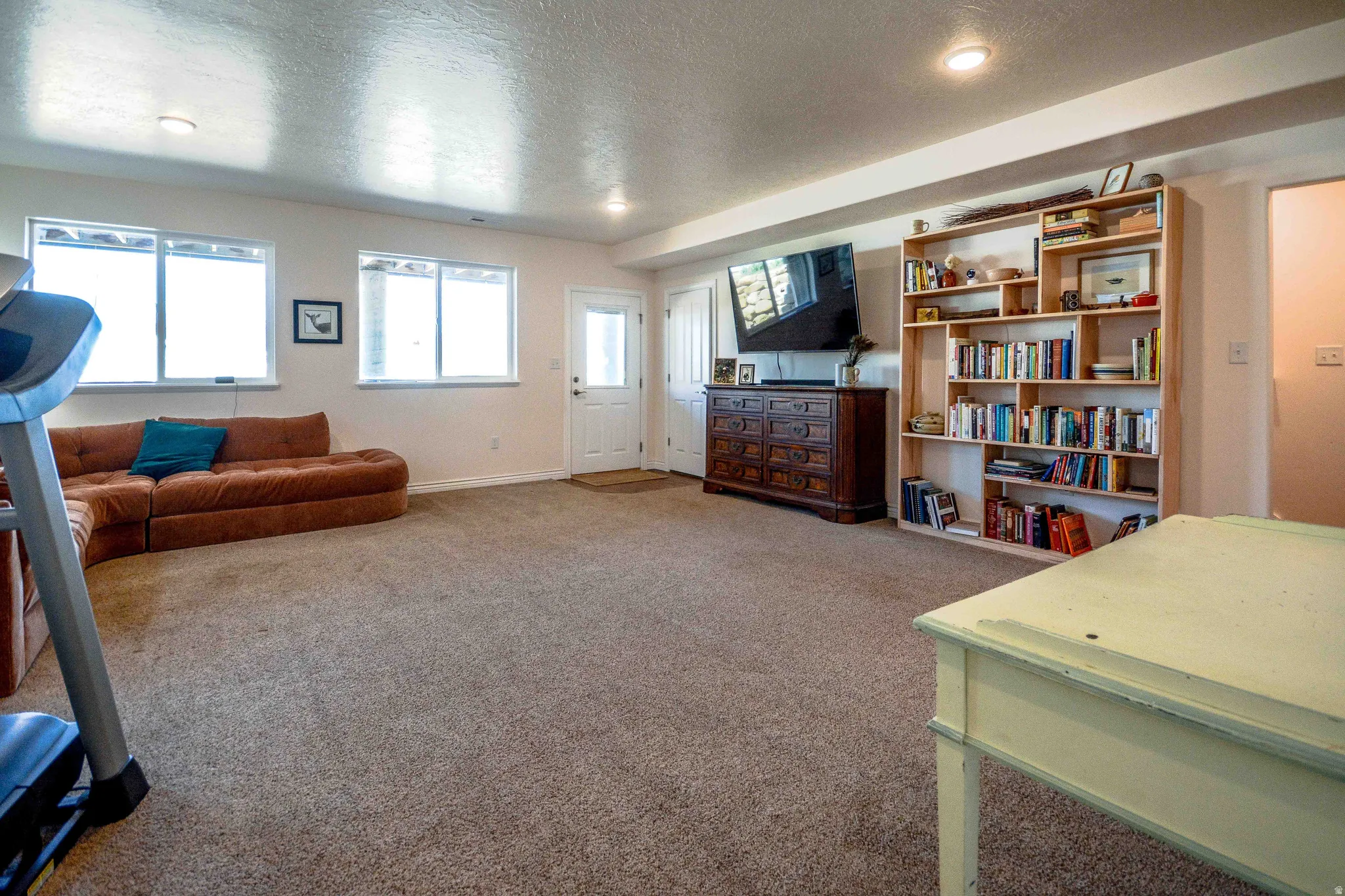 Spacious room featuring carpeting, recessed lighting, and a built-in shelving unit