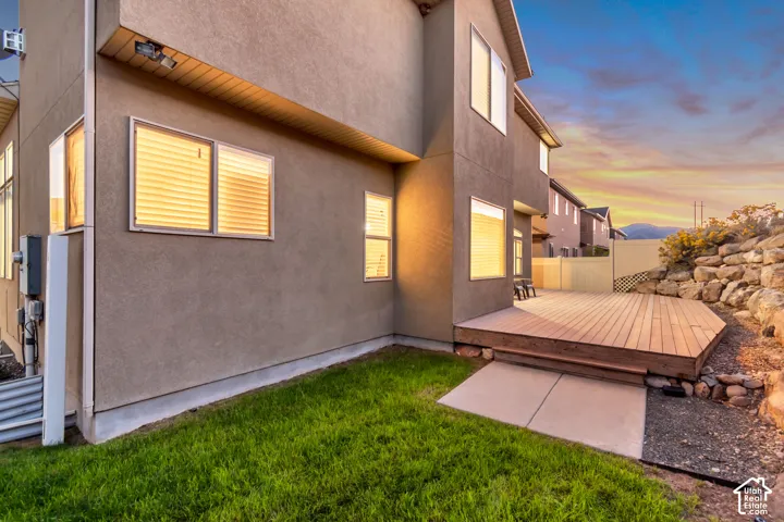 Stucco exterior with multiple windows, leading to an expansive wooden deck