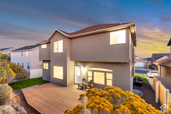 Spacious wood-finish deck, stucco exterior, multiple large windows, and a private rear entrance