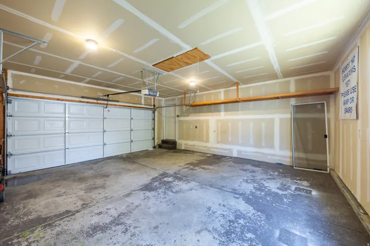 Two-car garage featuring a concrete floor, overhead lighting, and an automatic garage door opener