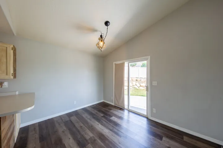 Dining area featuring wood-finish flooring and a vaulted ceiling