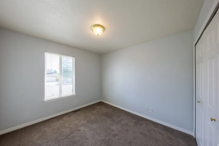 Neutral tone walls with white trim, brown carpet, and a double-door closet