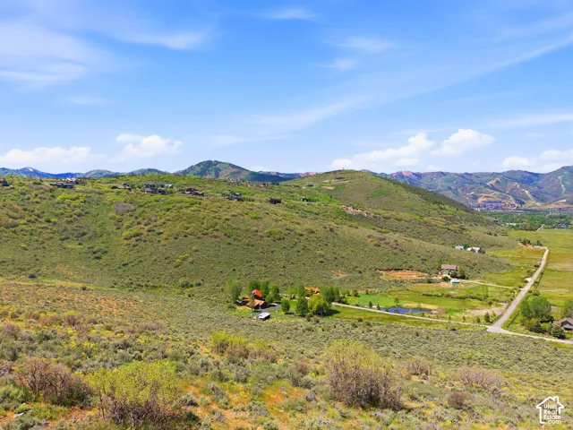 Expansive landscape featuring rolling hills and distant mountainous terrain
