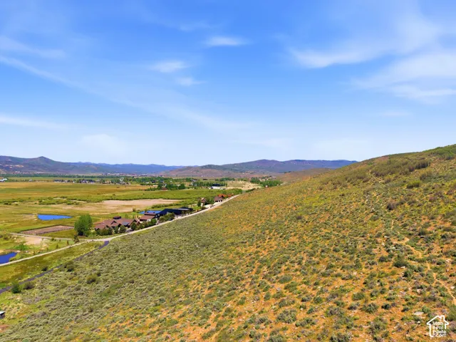Expansive rural landscape featuring a mountainous backdrop, a broad valley, and multiple bodies of water