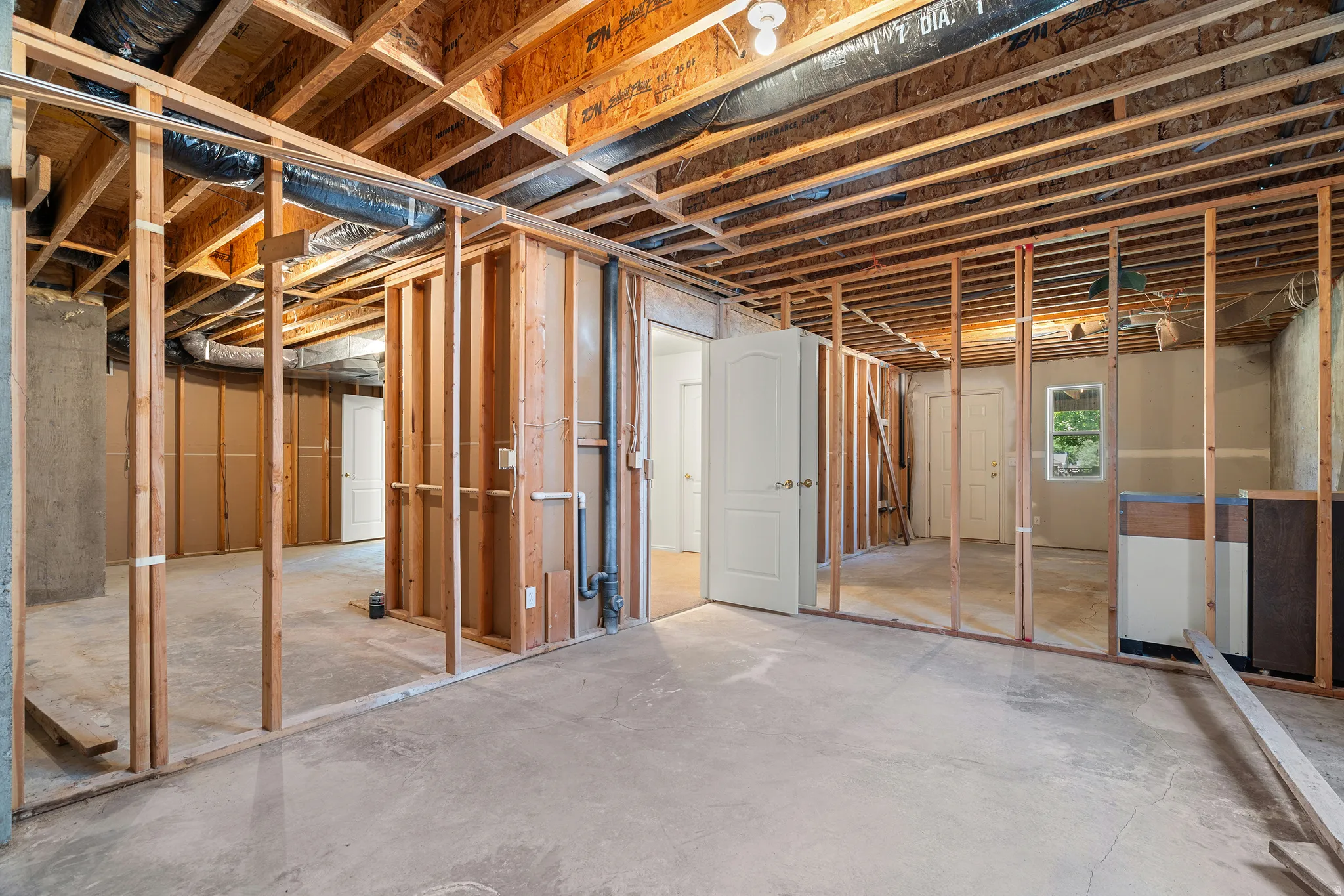 Unfinished basement with exposed wood framing and concrete flooring