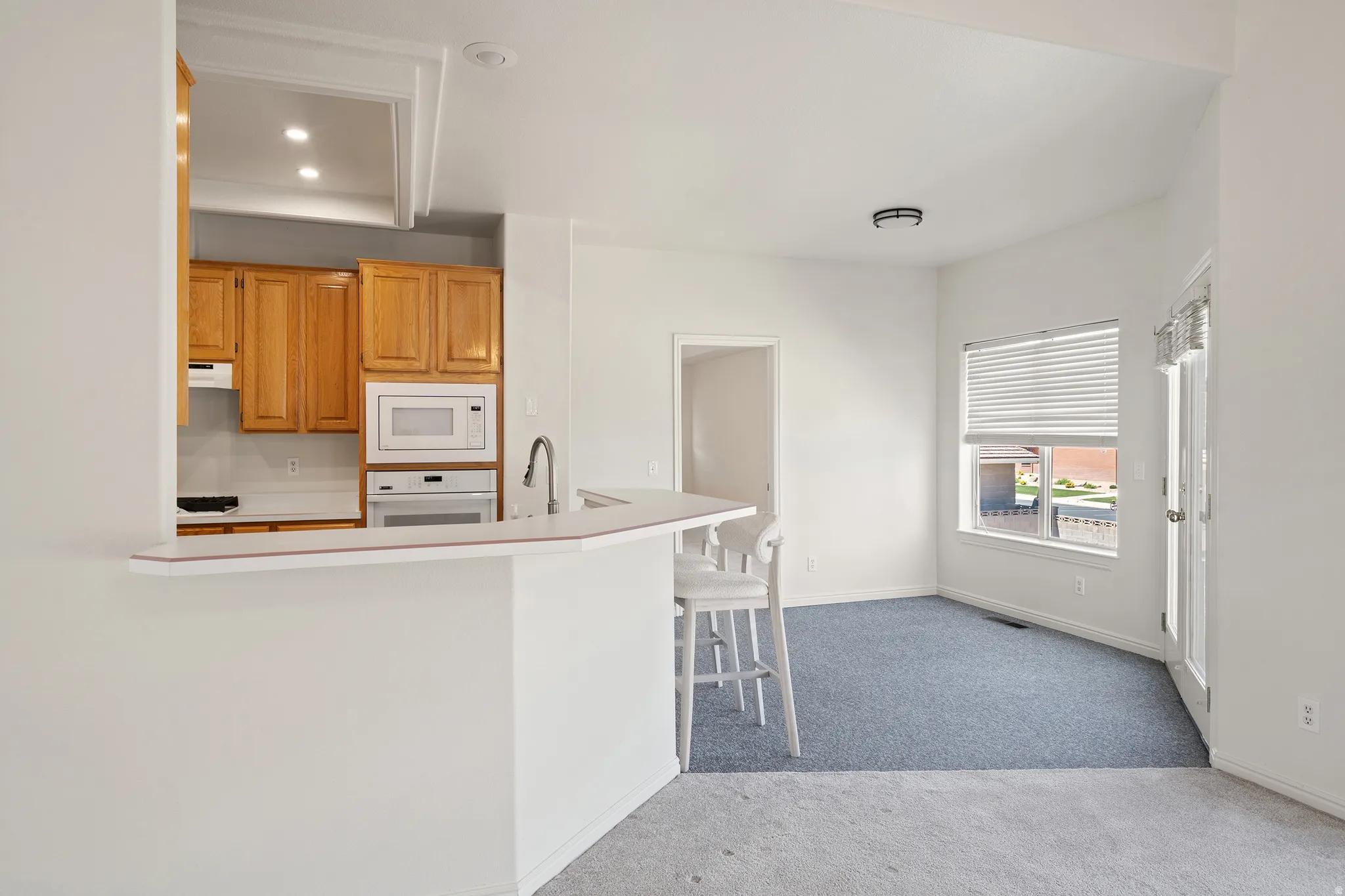 Kitchen with wood cabinetry, integrated appliances, and a breakfast bar
