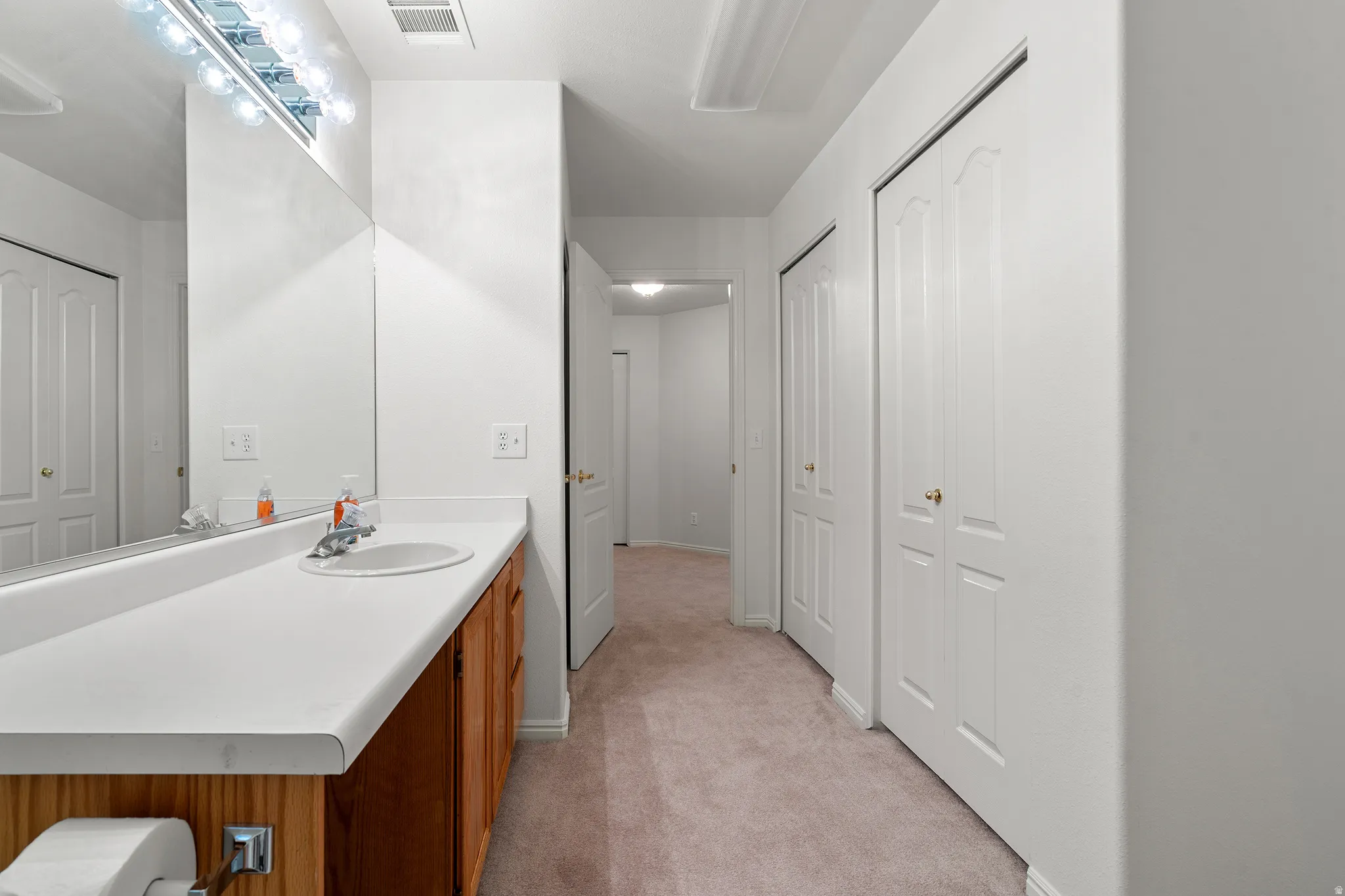 Full-width vanity with an integrated sink and wood-finish cabinetry