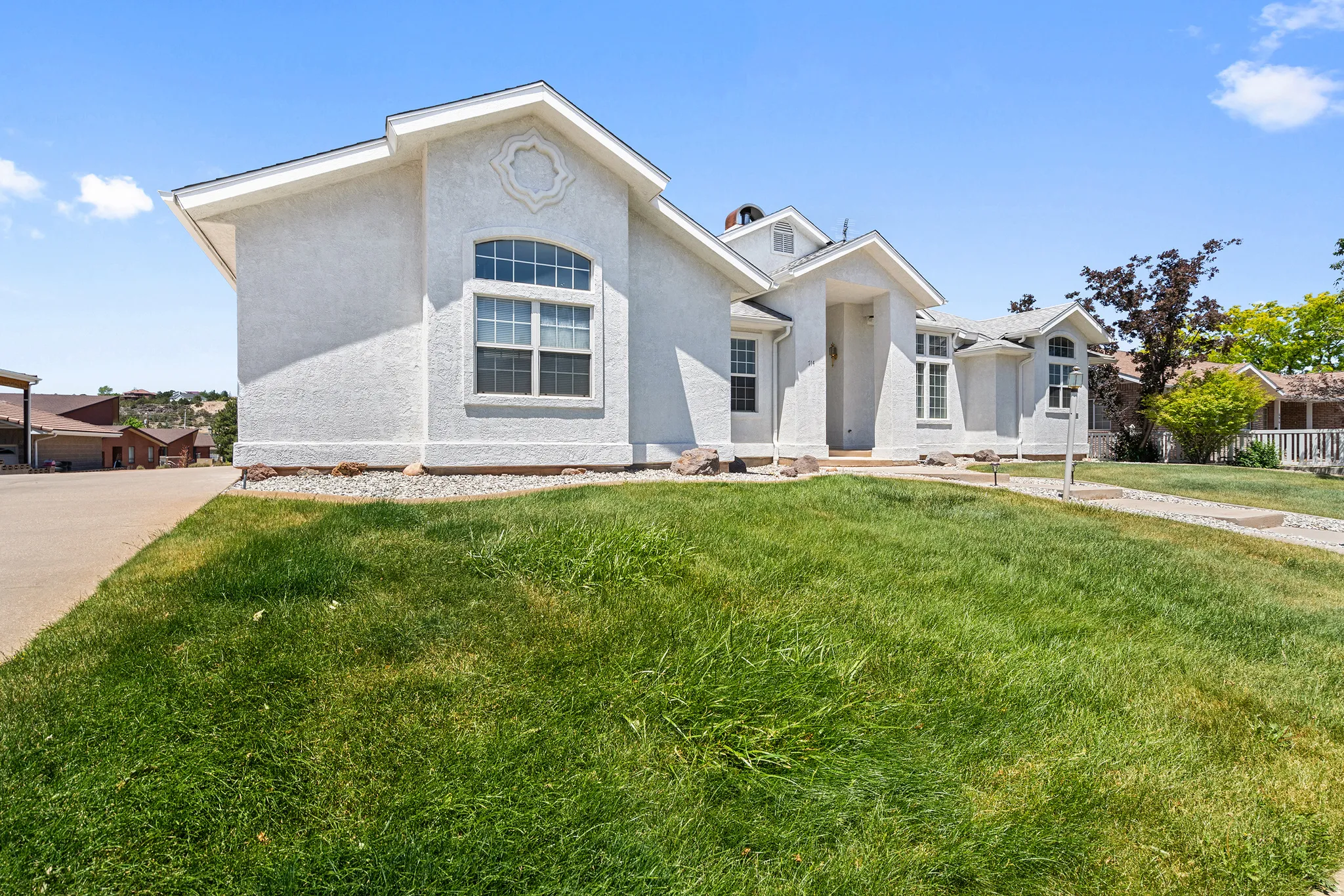 Contemporary stucco exterior featuring a gabled roofline and multiple window styles