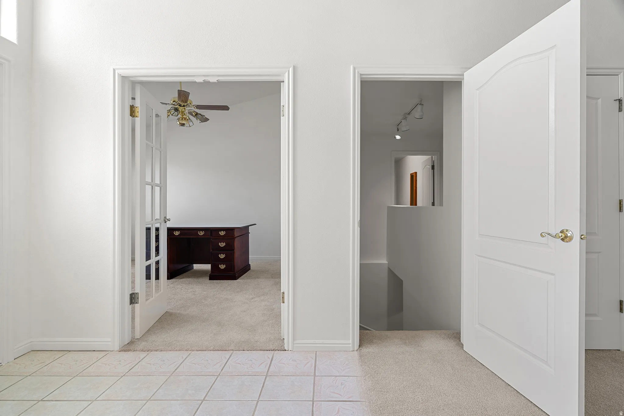 Bright interior hallway featuring tile flooring and two paneled interior doors
