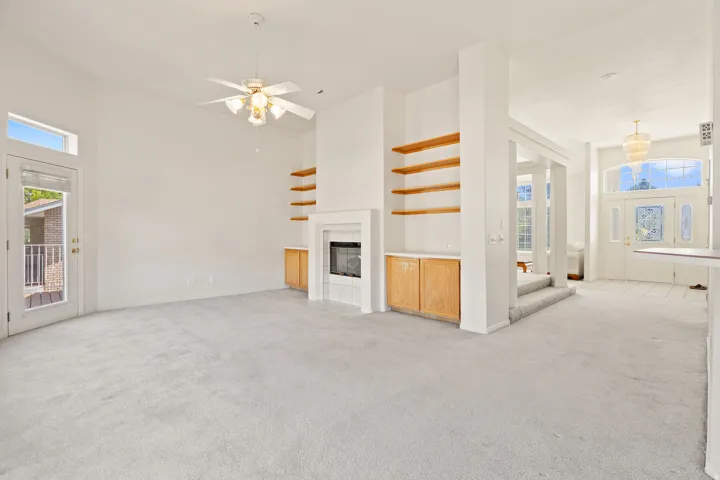 Spacious room with a fireplace, built-in shelving, and wood-finish cabinetry