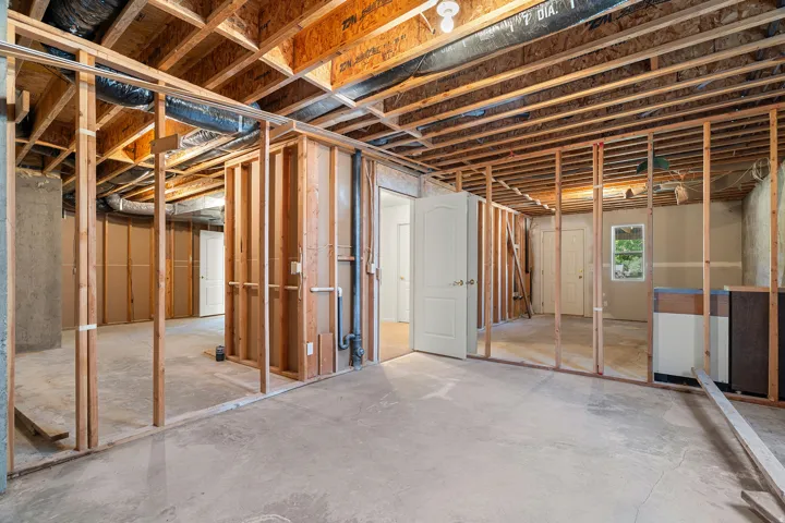 Unfinished basement with exposed wood framing and concrete flooring