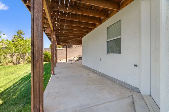 Covered patio featuring a concrete slab and exposed wood beam ceiling