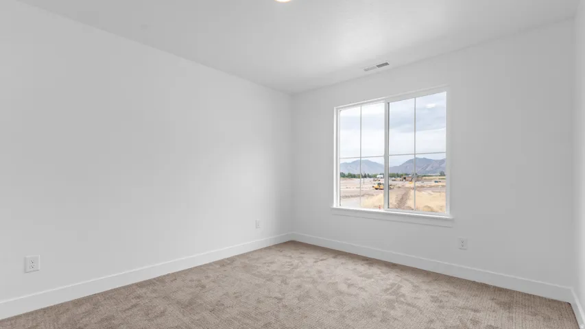 Bright room with a large window, plush carpet, white walls, and white trim