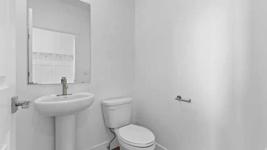 Pedestal sink with a contemporary brushed nickel faucet and a rectangular mirror