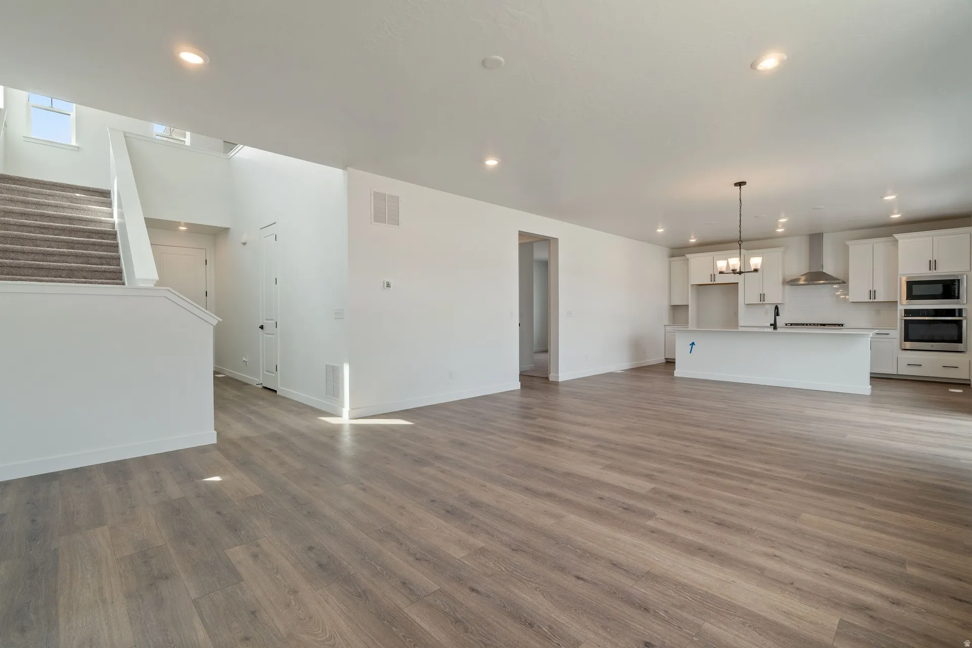 Spacious interior featuring wood-finish flooring, white walls, and recessed lighting