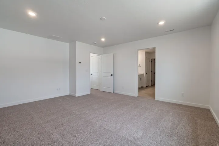 Neutral-toned carpeted room with recessed lighting