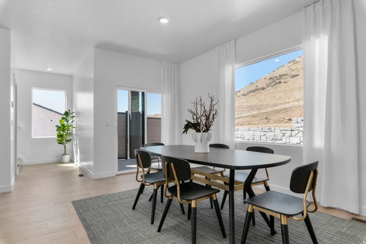 Dining area featuring light wood-finish flooring, white walls, and recessed lighting