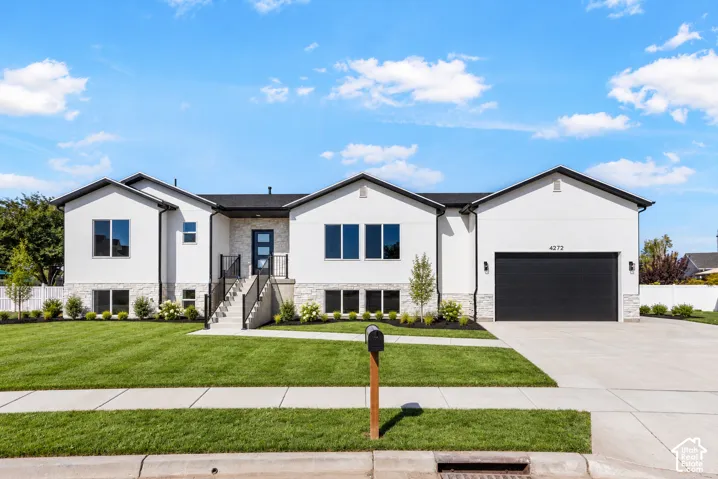 Contemporary exterior with a white stucco finish, stone veneer accents, black-framed windows, a black garage door, and a concrete driveway