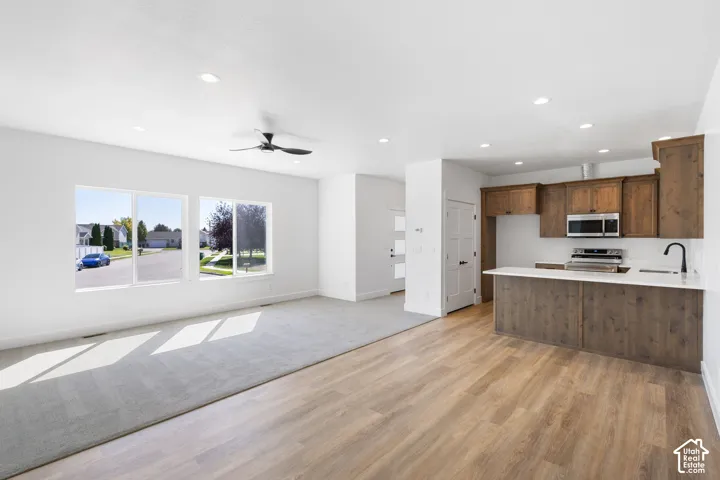 Open-concept living space featuring wood-finish flooring, recessed lighting, and a ceiling fan