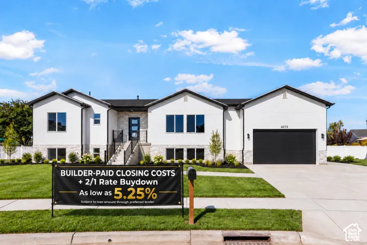 Contemporary exterior featuring smooth stucco siding, stone veneer accents, three-car garage, and extended RV pad!