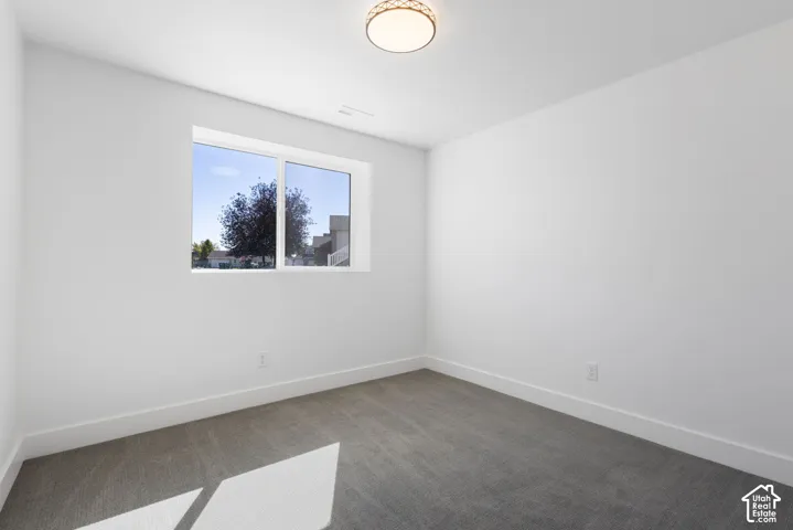 Recessed lighting, large window, neutral carpeting, and white trim