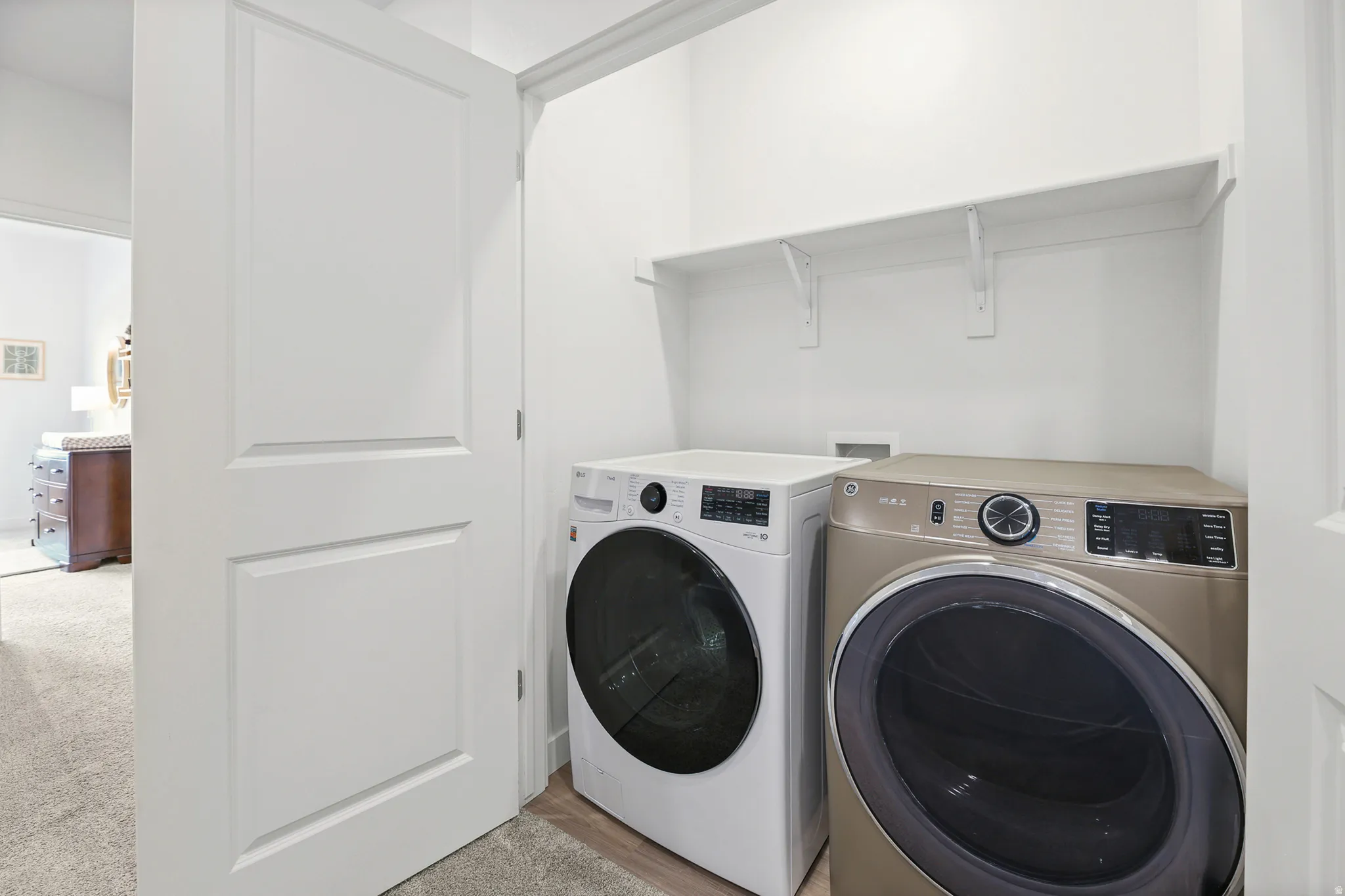 Dedicated laundry area featuring a built-in white shelf and neutral-toned wall paint