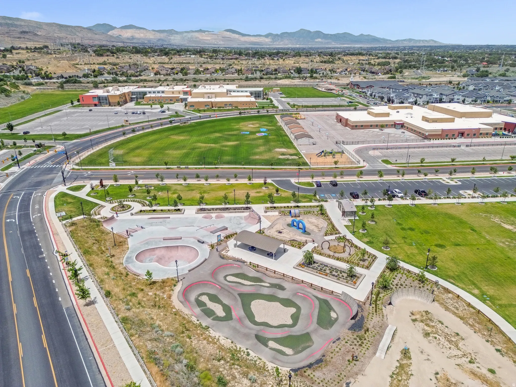 Aerial perspective showcasing a community park with a skate park and pump track