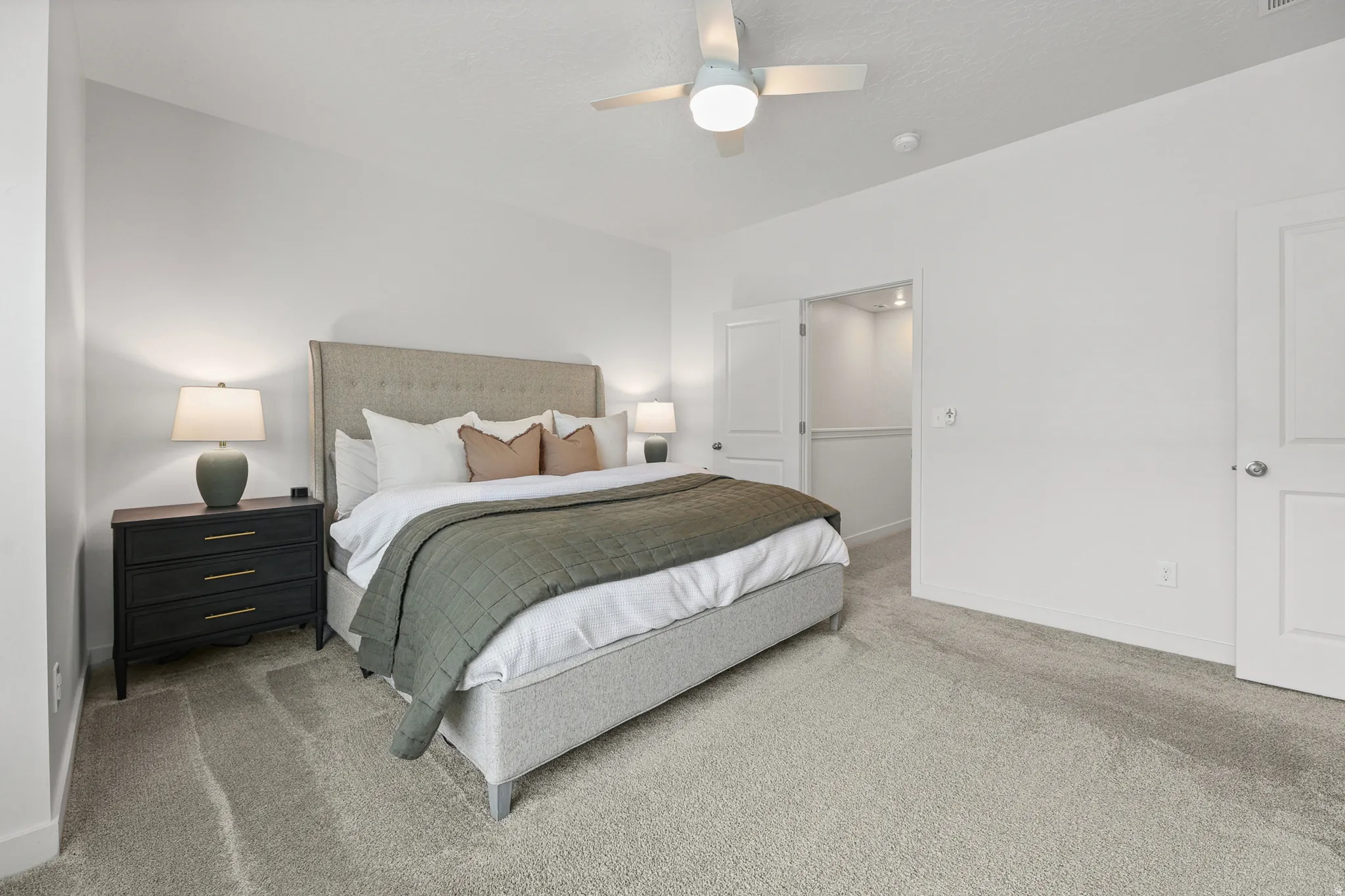Bedroom featuring plush carpet flooring, a ceiling fan with integrated lighting, and crisp white walls