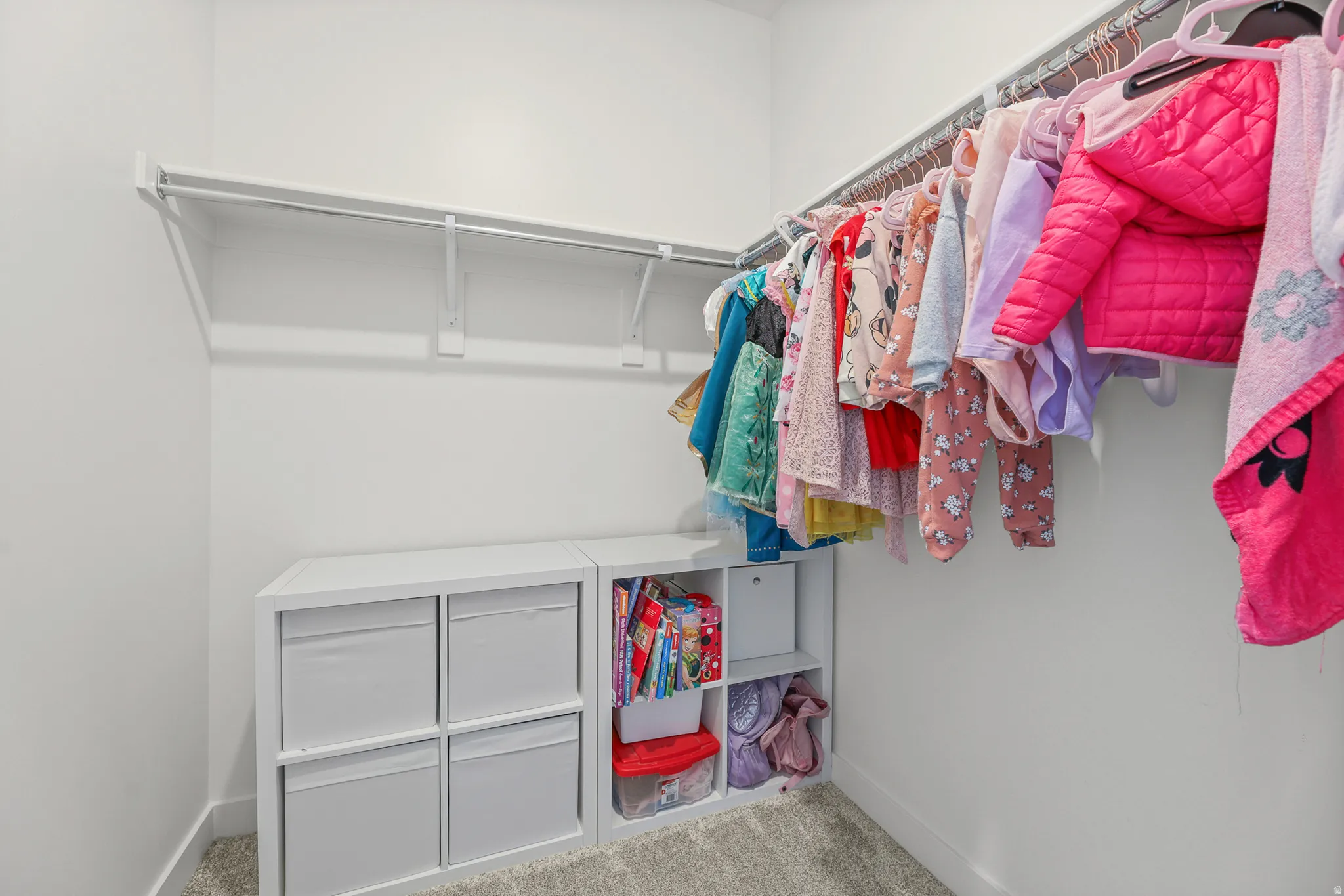 Spacious closet featuring white walls, carpeting, and a built-in wire shelving system for ample storage
