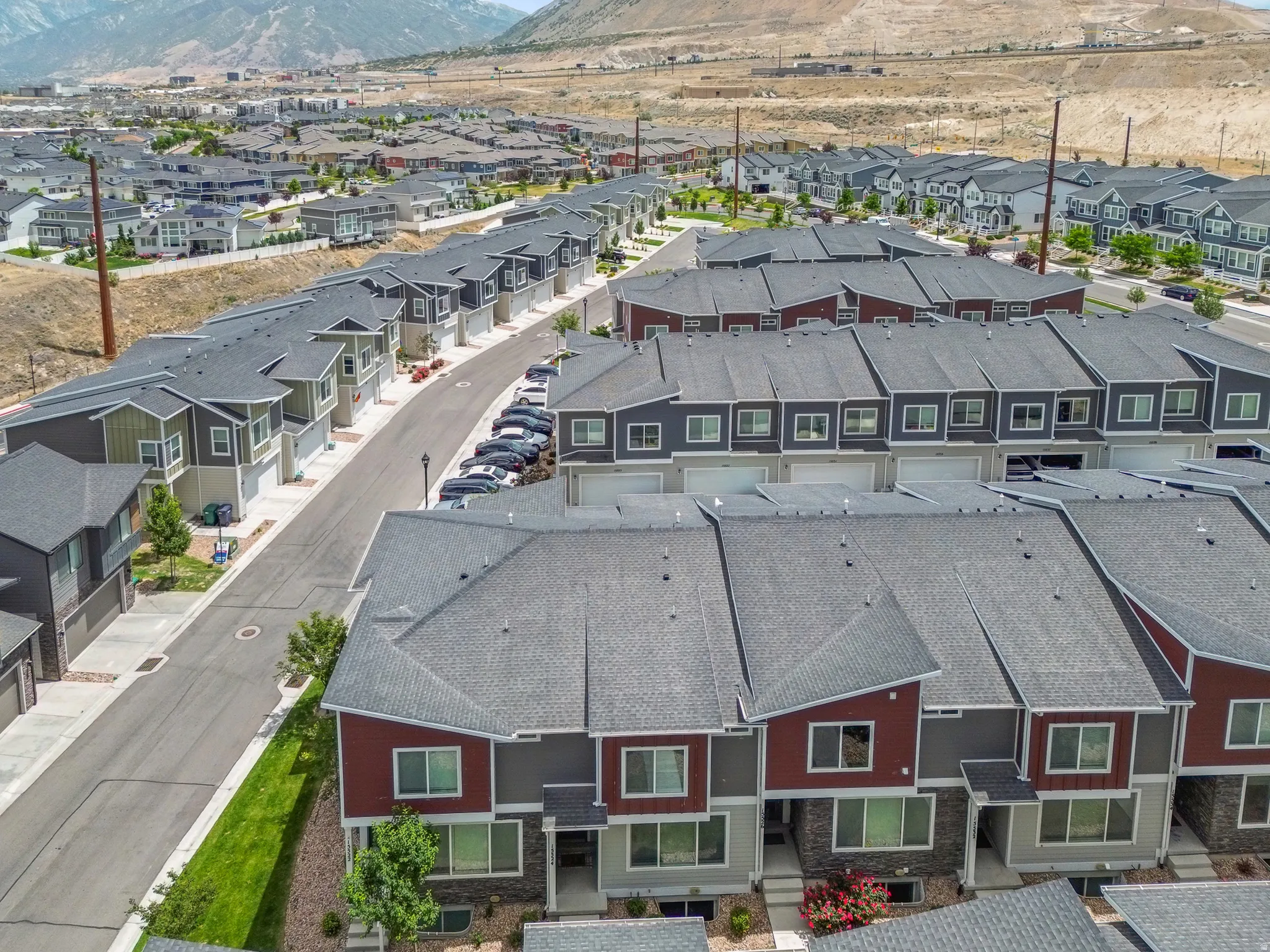 Modern townhome community featuring contemporary architectural styles, multiple color palettes, attached garages, and proximity to mountainous terrain