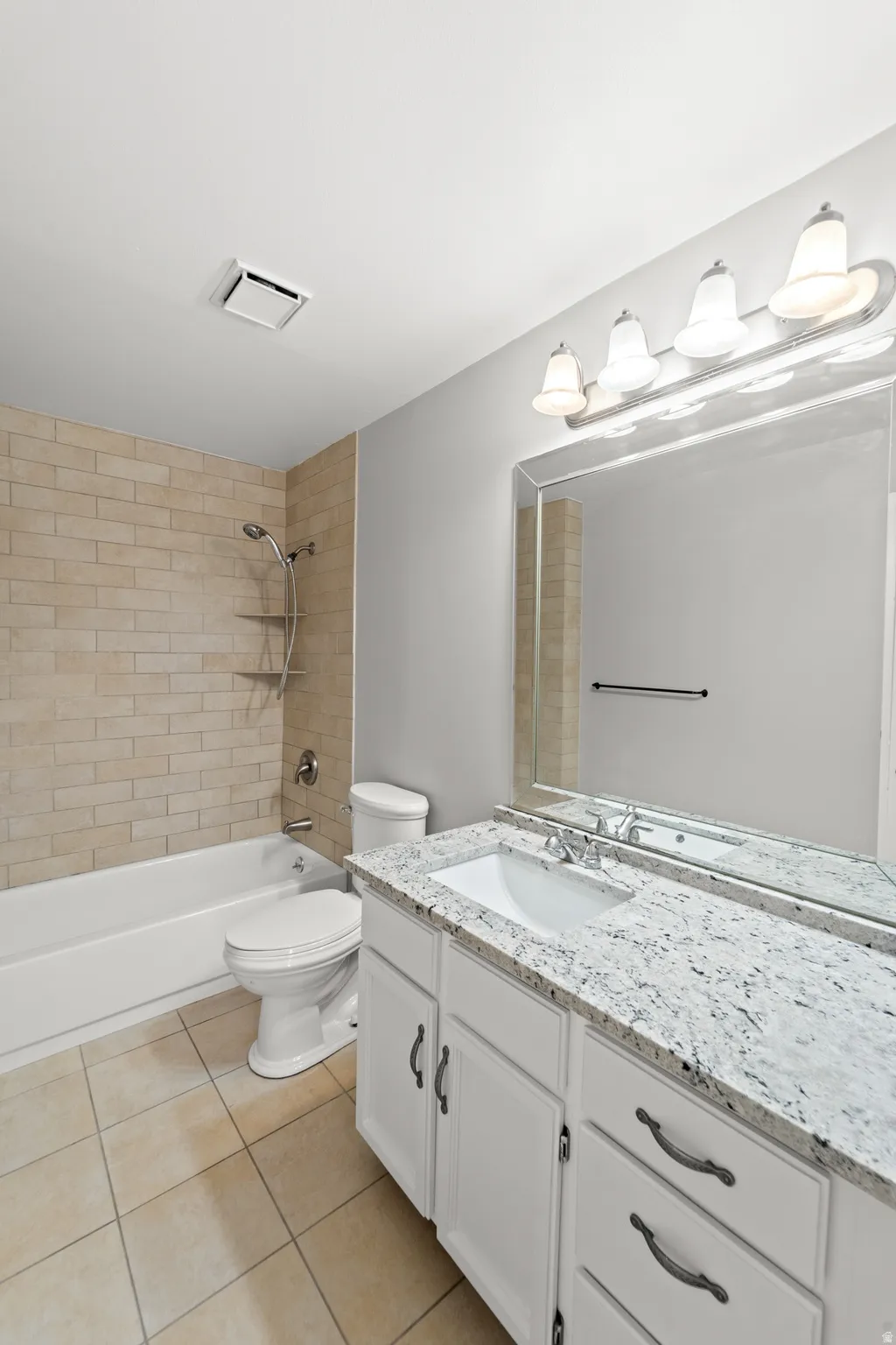 Well-appointed primary bathroom features upgraded granite countertops.