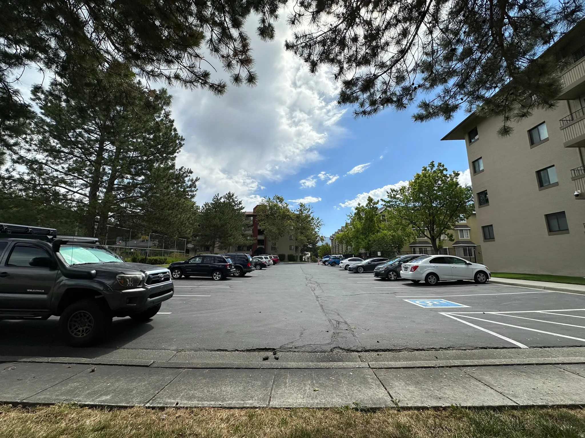 Spacious asphalt parking lot with striped parking spaces and a designated accessible parking spot