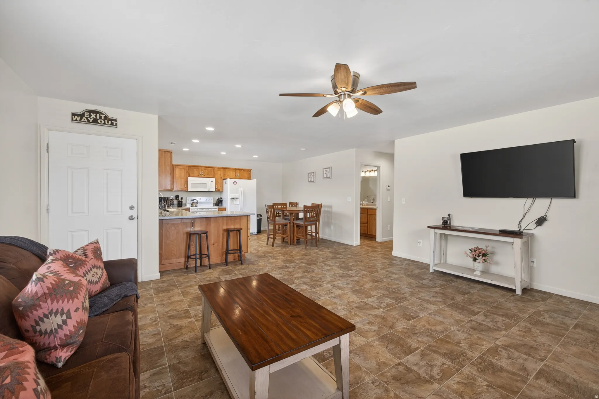 Open-concept living area featuring tile flooring, a ceiling fan with light fixture, and recessed lighting